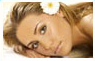 Woman resting with flower in hair – facial and plastic surgery services at Medical Eye Associates surgical center