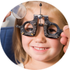 Young girl undergoing eye exam with phoropter – pediatric vision care and eye exams at Medical Eye Associates